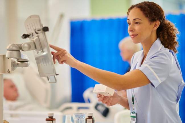 infirmière avec des médicaments au chevet du patient