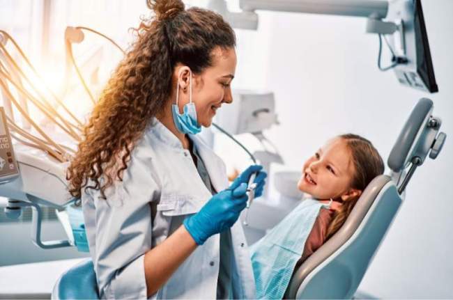 Dentist with pediatric patient in a chair