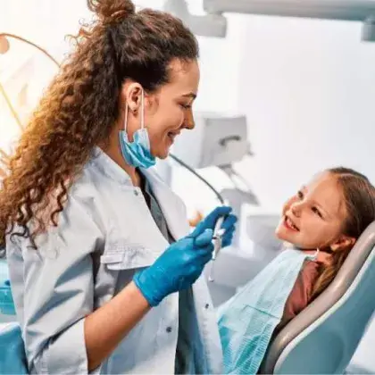 Dentist with pediatric patient in a chair
